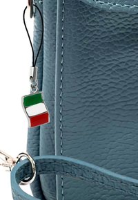 Blauwe leren tas met textuur en een zilveren hanger met de Italiaanse vlag. Beschikt over een bijpassende blauwe schouderband en zilveren hardware-accenten.