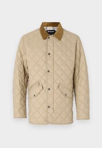 Beige quilted jacket with a corduroy collar, featuring snap closures and two angled front pockets. Smooth fabric texture, classic design.