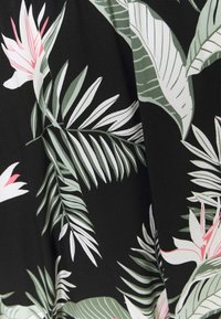 Tissu à motif floral présentant de grandes feuilles de palmier vertes et des fleurs roses sur un fond noir, avec une texture lisse et mate.