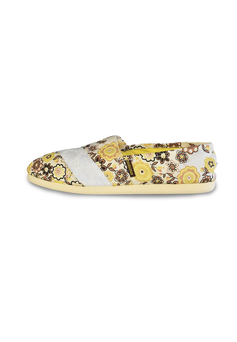 Los zapatos slip-on florales presentan una parte superior de tela en blanco y amarillo con un patrón de flores. La suela es de un amarillo claro, garantizando un diseño informal.