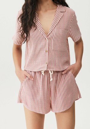 Gestreept twee-delige set in koraal en wit, bestaande uit een kortärmelige overhemd met knopen en shorts met trekkoord en zakken. Van katoen.