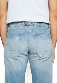 Světle modré denimové džíny s rovný střih, se dvěma zadními kapsami, jemným vyblednutím a kovovou sponou.