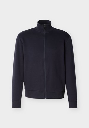 Chaqueta azul marino con cremallera completa, cuello, puños y dobladillo acanalados, con un pequeño logo en relieve en el lado izquierdo del pecho.