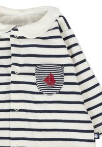 Pasiasta biała i granatowa koszula z białym kołnierzykiem, z lewą kieszonką na piersi, na której znajduje się haftowana czerwona łódka żaglowa oraz zapięcie na guziki.