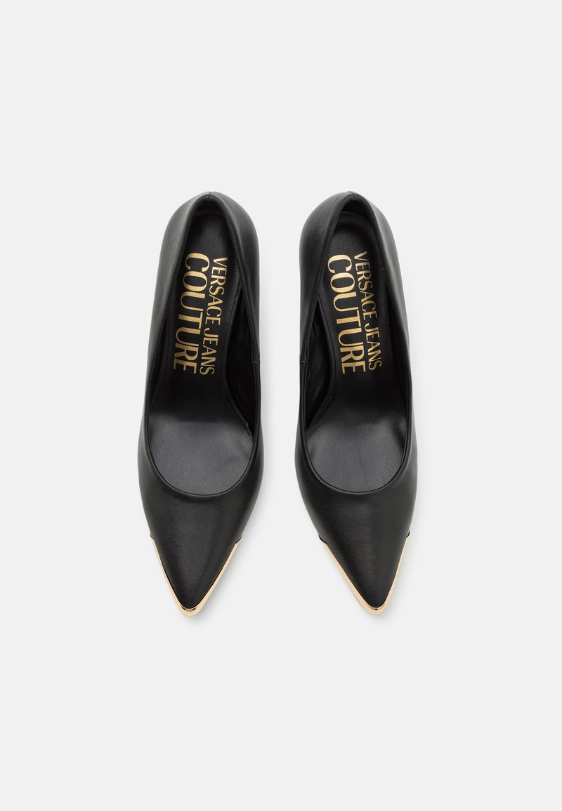 Escarpins en cuir noir à bout pointu, avec un accent doré à la pointe, un intérieur de marque et une texture lisse.