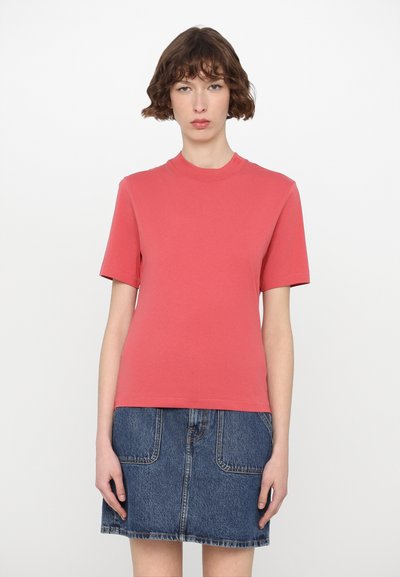 Koralfarvet t-shirt med korte ærmer, rund halsudskæring, blødt bomuldsstof med en glat tekstur. Sammen med en denimnederdel med laplommer.