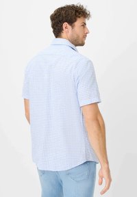 Camicia a maniche corte in azzurro chiaro con motivo a quadretti bianchi, realizzata in cotone traspirante, con colletto classico e orlo curvo.