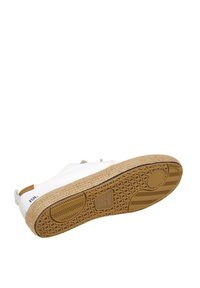 Scarpa slip-on bianca in tela con una suola intermedia in juta marrone chiaro e una suola esterna in gomma strutturata, caratterizzata da un branding minimale e senza hardware visibile.