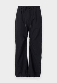 Pantalons noirs amples en tissu léger, dotés d'une taille élastique avec cordon de serrage et de poignets froncés aux chevilles.