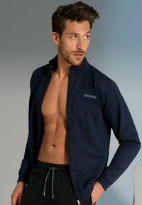 Mariene zip-up jack in zachte stof met een hoge kraag, met een subtiele "Bench." logo op de borst; gecombineerd met zwarte shorts met koord.