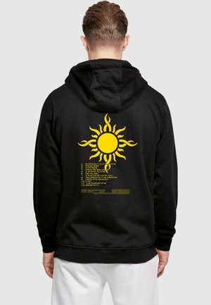 Schwarzer Hoodie mit einem großen gelben Sonnenmotiv auf der Rückseite, darunter steht der Text mit Songtiteln in einem Rasterformat.