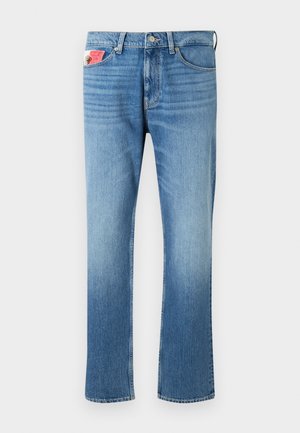 Jeans in denim blu sbiadito con vestibilità dritta, dotati di chiusura a bottone, cinque tasche e una toppa sulla tasca anteriore.