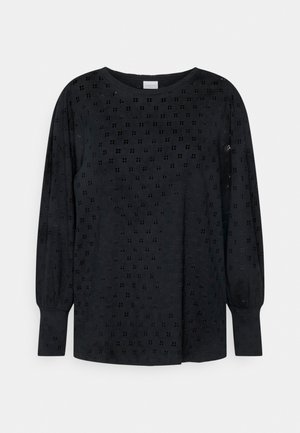 Blusa negra de manga larga con pequeño patrón de ojales cuadrados, escote redondo y mangas ligeramente abullonadas con puños.