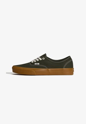 Canvas sneakers in donkergroen met een zool van rubber in karamelkleur. Voorzien van witte veters en stiksels. Laag model met een afgeronde neus en logodetail.