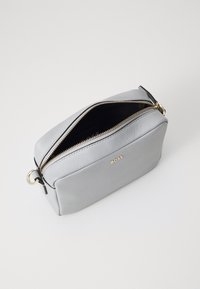 Borsa in pelle grigia con forma rettangolare, zip dorata, interno nero e logo impresso. Presenta un anello laterale per attacchi.