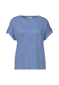 Haut femme bleu clair à manches courtes avec manches retroussées maintenues par des pattes à bouton et col rond.