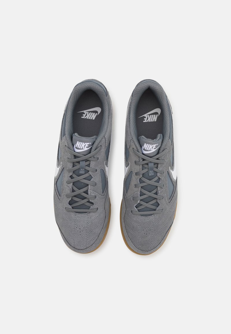 Grijze Nike-sneakers van suède en mesh, met een wit logo, een getextureerd oppervlak en een gumrubberen zool. Vormgegeven voor comfort en ondersteuning.