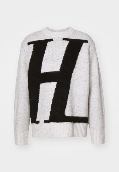 Szürke kötött pulóver, melynek elülső részén egy nagy fekete "H" található, bordázott mandzsettákkal és nyakkal. Puha tapintású, laza illeszkedésű kialakítással.