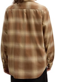 Bruine en crèmekleurige geruite shirt met een button-down kraag, een enkele plooi aan de achterkant en knoopmanchetten. Zacht, geweven stof met een relaxte pasvorm.