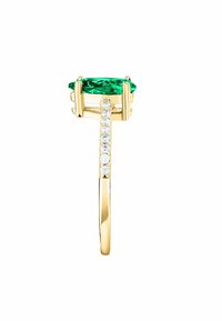 Anello in oro con una pietra verde ovale, enfatizzato da una fila di pietre chiare lungo la banda. Finitura liscia e lucida.
