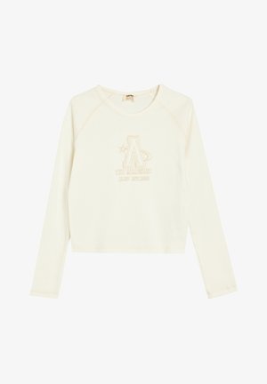 Sudadera de manga larga color crema con cuello redondo, que presenta un diseño de logo en relieve en color beige y detalles de costura sutiles.