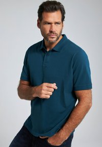 Mörk teal polo skjorta för män i mjukt tyg. Har en klassisk krage, korta ärmar och en tvåknapprad, med en rak fåll.