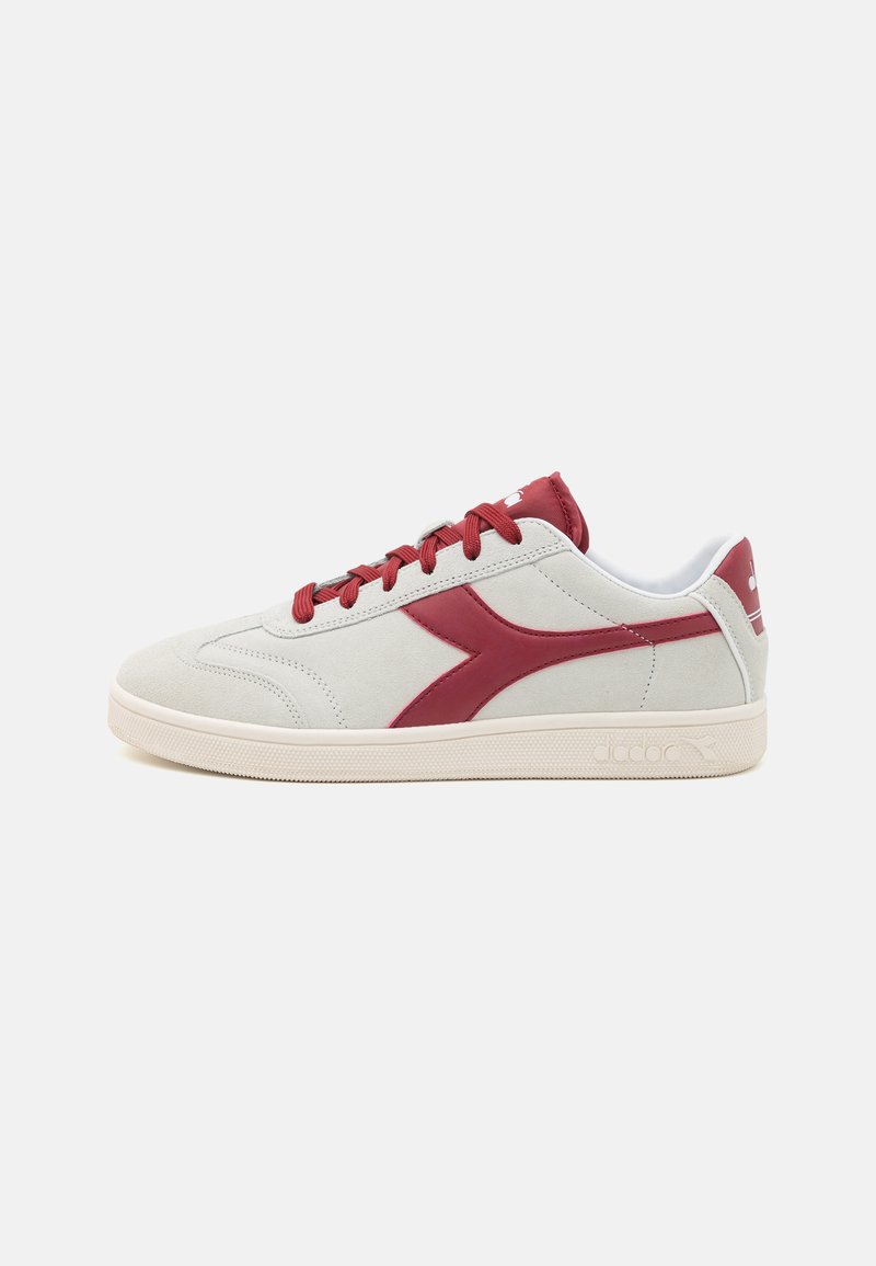 Grå semsket sneakers med en burgunder sidestrek, matchende lisser og en beigefarge gummisåle. Har logo på tungen og hælen.
