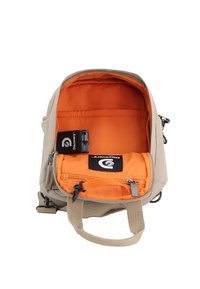 Tan backpack with an orange interior, featuring zipper closure, adjustable straps, and multiple inner pockets for organization.