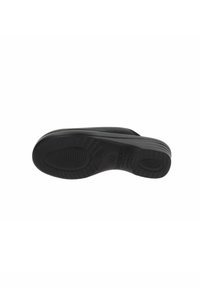 Suola nera di scarpa con superficie in gomma testurizzata, con scanalature per presa e stabilità. Tacco leggermente elevato per comfort e supporto.