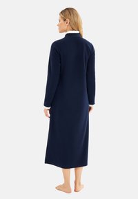 Long navy fleece robe with a white collar, featuring long sleeves and a straight hem. Soft texture, designed for warm, comfortable wear.