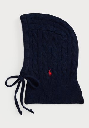 Tumesinine koer knitted müts, ümmarguse kujuga, millel on punane logo ja sidemed alusel, et tagada kindel sobivus. Pehme villasegu materjal.