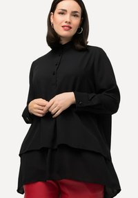 Black long-sleeve blouse with a high collar, featuring a buttoned front and layered design. Smooth fabric with a relaxed fit and subtle sheen.