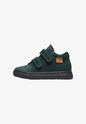 Zapatillas de ante verde con correas de velcro, suela de goma, puntera reforzada y detalle de cuero en el talón. Costuras detalladas visibles.
