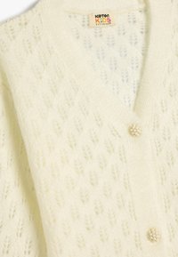 Vitt stickat cardigan med v-ringning, bladmönster och en dekorativ knapp. Tillverkad av mjukt, texturerat material.