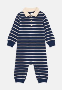 Romper pour bébé à manches longues rayé bleu marine et beige avec un col beige, patte de boutonnage, fermetures à pression au niveau des jambes et bords côtelés.