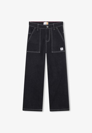 Pantaloni in denim nero con vestibilità ampia, cuciture bianche, grandi tasche anteriori e un'etichetta con logo sulla tasca destra.