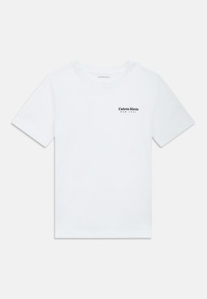 Bijela majica kratkih rukava Calvin Klein s malim crnim logotipom "Calvin Klein New York" na gornjem lijevom dijelu prsa.