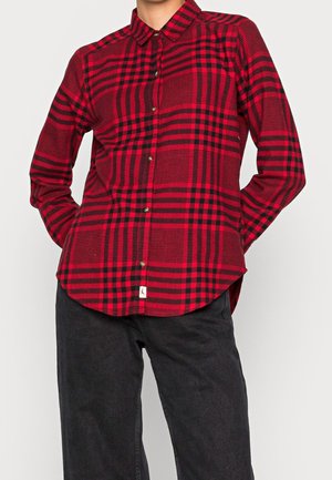 Camicia a maniche lunghe a quadri rossi e neri con colletto, chiusura a bottoni e orlo curvo. Realizzata in un tessuto testurizzato. Vestibilità casual.