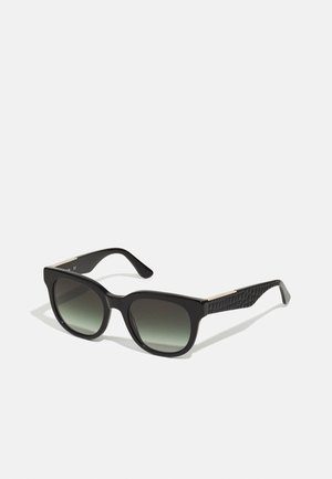 Ochelari de soare negri cu lentile gradient, rame pătrate, brațe texturate negre și accent de aur lângă balama. Construcție din plastic ușor.