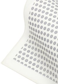 Teksturowana tkanina w odcieniu kremowym z wzorem równomiernie rozmieszczonych szarych owalnych kropek, charakteryzująca się miękkim i elastycznym fasonem.