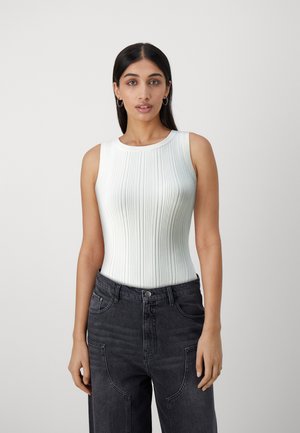 Vaaleansininen ribattu bodysuit, jossa on pyöreä kaula-aukko ja hihattomuus, yhdistettynä korkeavyötäröisiin mustiin farkkushortseihin, joissa on ainutlaatuinen ompelu.
