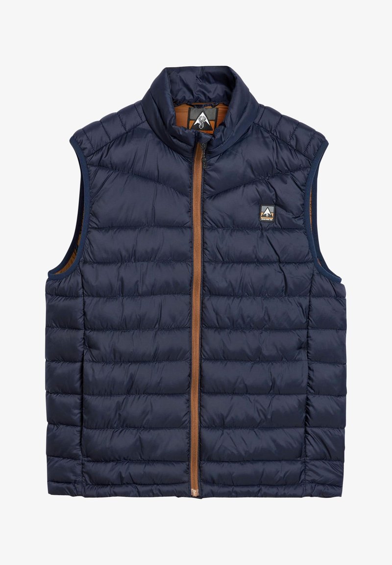 Navy blue quilted sleeveless vest with brown zipper and high collar, featuring a small triangular logo patch on the chest.