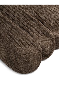 Brune ribbede sokker med en myk tekstur, som har forsterket tå og hæl for bedre holdbarhet. Nærbilde viser detaljer i sømmen.