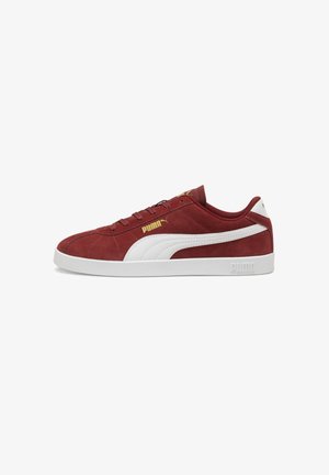 Czerwone zamszowe sneakersy z białym skórzanym paskiem, z detalami w złotym logo, okrągłym noskiem i białą gumową podeszwą.