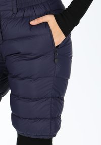 Shorts in nylon imbottiti di colore blu navy con design a trapunte, dotati di tasca laterale con zip e vita elasticizzata per una vestibilità e un comfort regolabili.