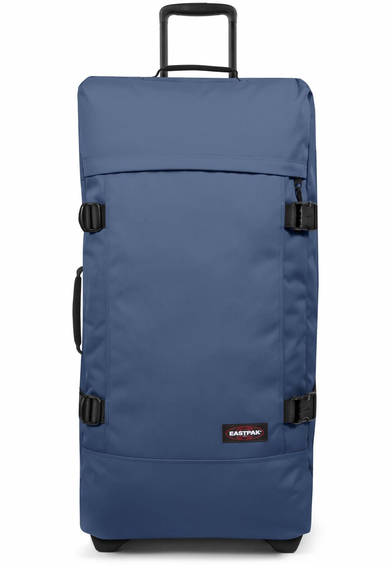 Bolso de viaje de tela azul con un asa telescópica, hebillas y un bolsillo frontal. Cuenta con una base sólida y el logo de Eastpak en la parte frontal.