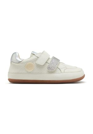 Zapatilla blanca con cuero perforado, acentos plateados y dos correas de Velcro. Presenta una suela texturizada y un logo circular en el lado.