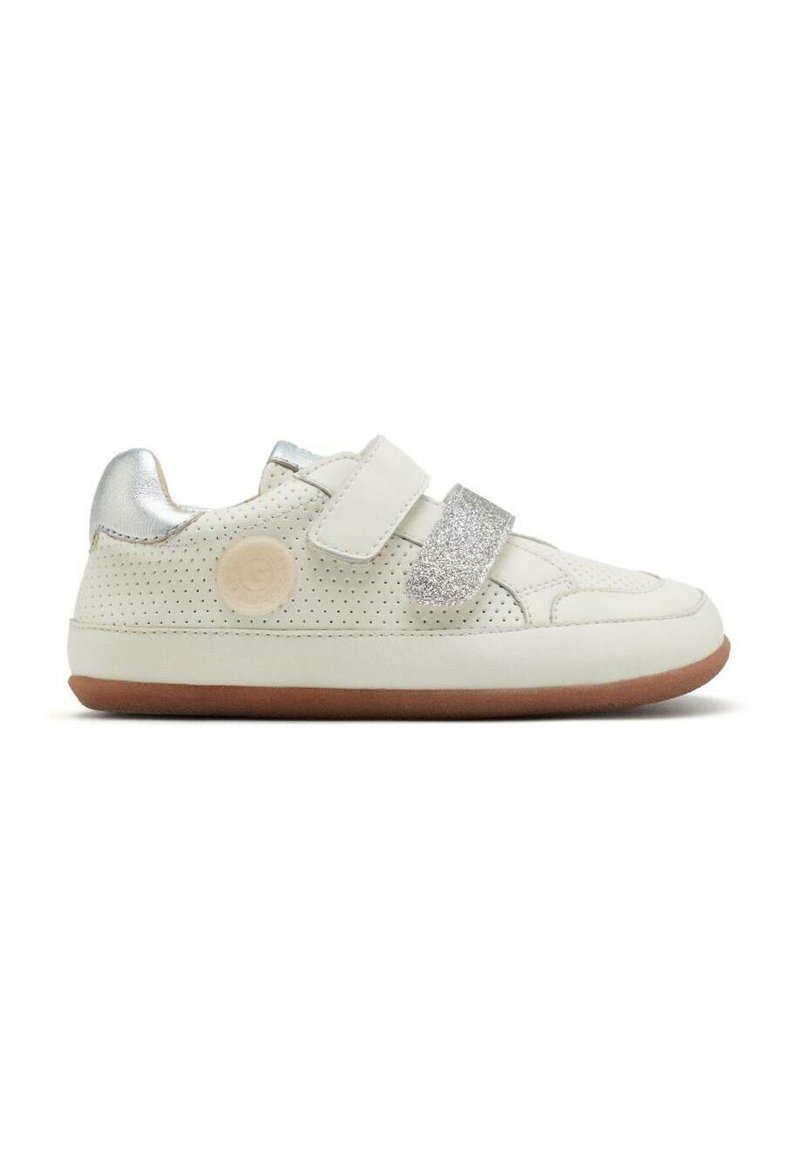 Zapatilla blanca con cuero perforado, acentos plateados y dos correas de Velcro. Presenta una suela texturizada y un logo circular en el lado.