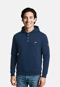 Navyblauwe hoodie van zachte stof, met een knoopsluiting, een berenlogo op de borst en geribde manchetten.