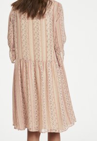 Robe à motif floral dans des teintes pastel, avec des rayures verticales, un ourlet en cascades et des manches trois-quarts avec des poignets retroussés.